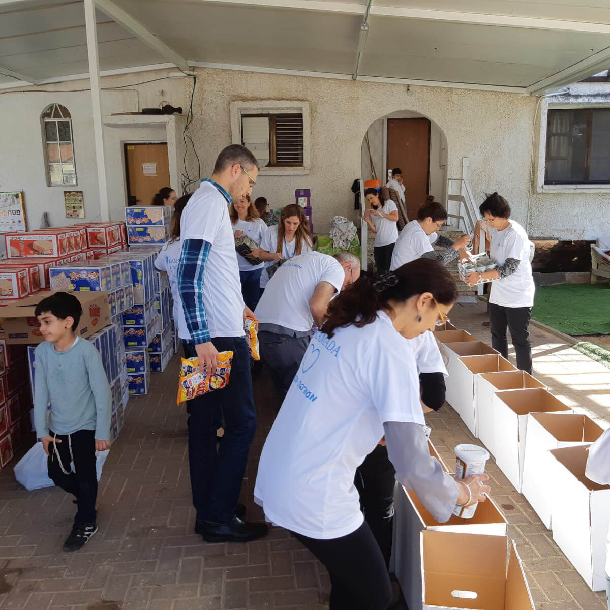 פעילות של מתנדבים באריזת סלי מזון בעמותת לחיות בכבוד